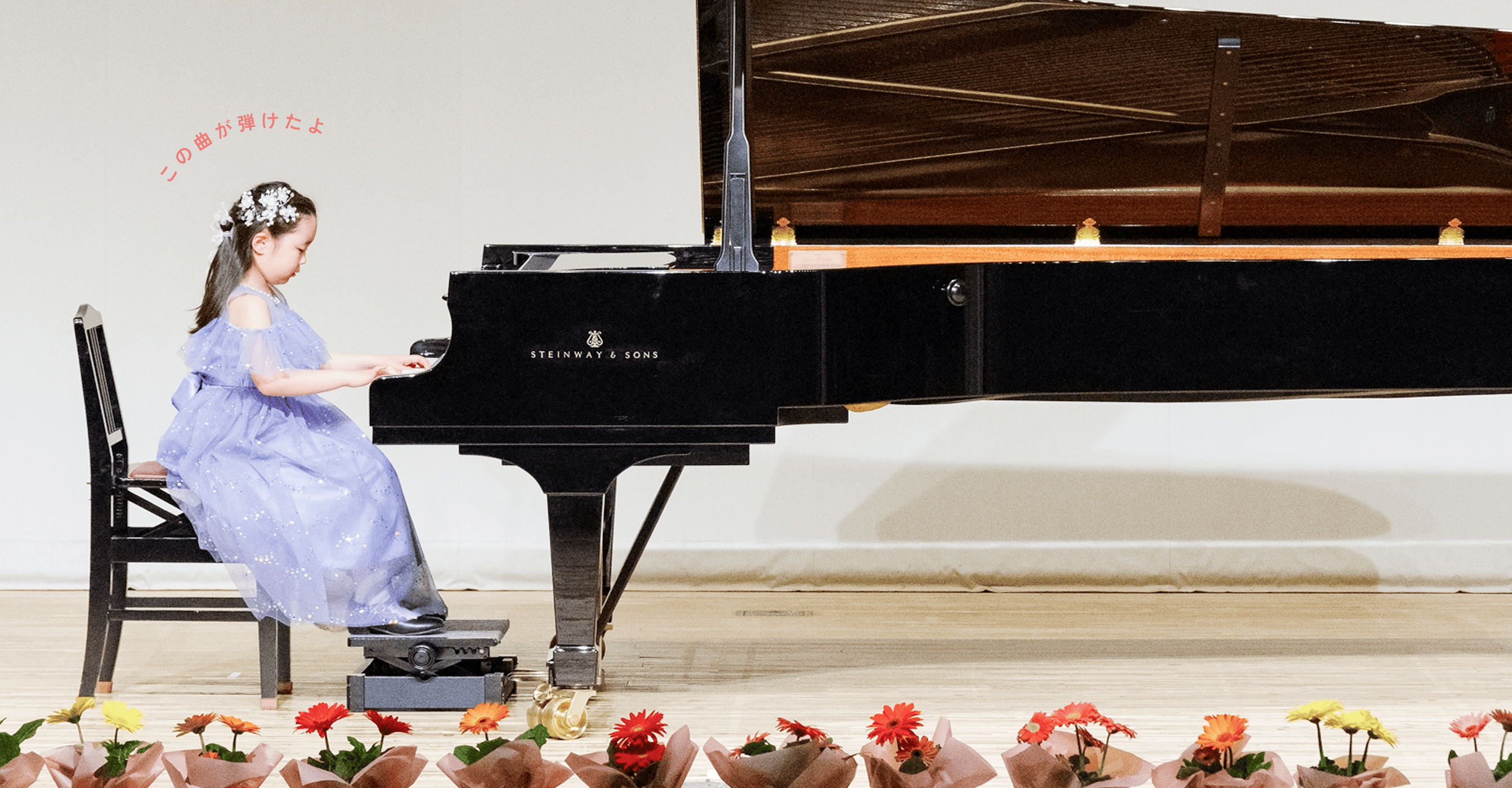 ピアノ発表会の様子 紫色のドレスでピアノを弾く女の子